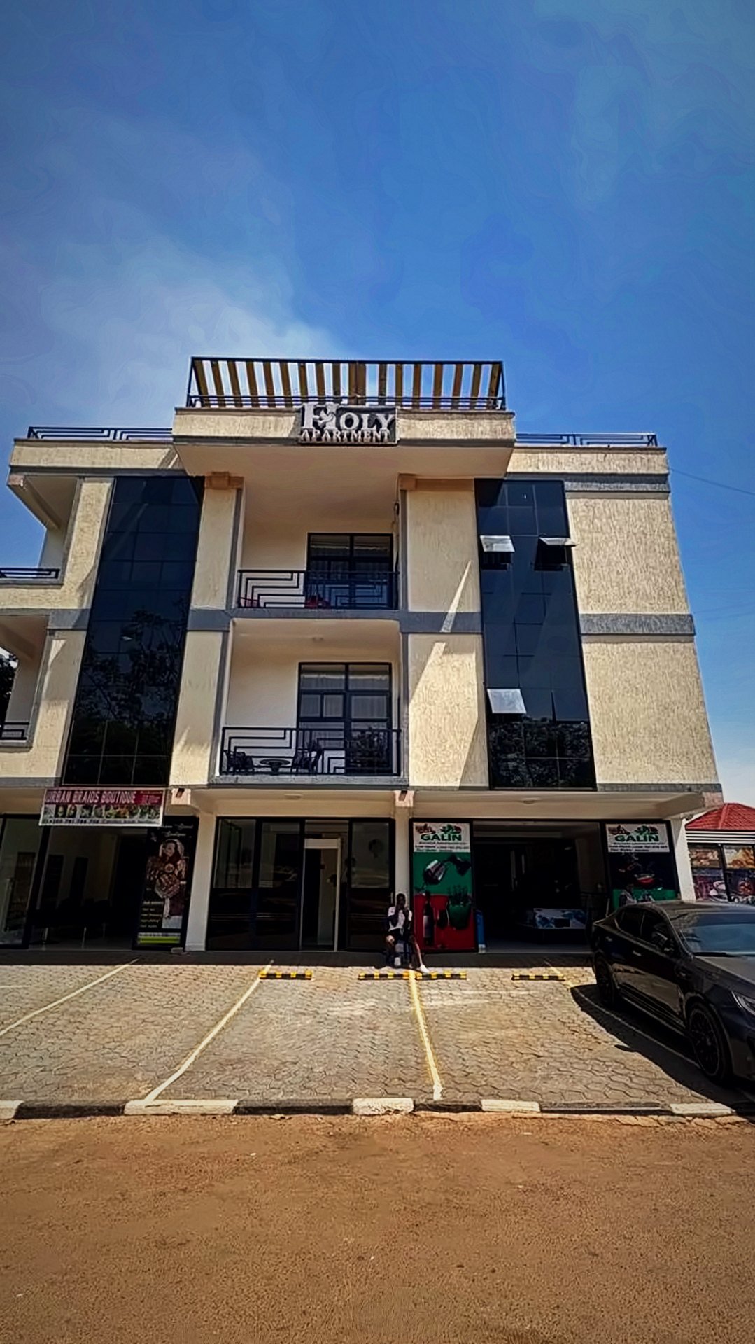 Holy Apartments building in Kigali with balconies on every floor and a rooftop