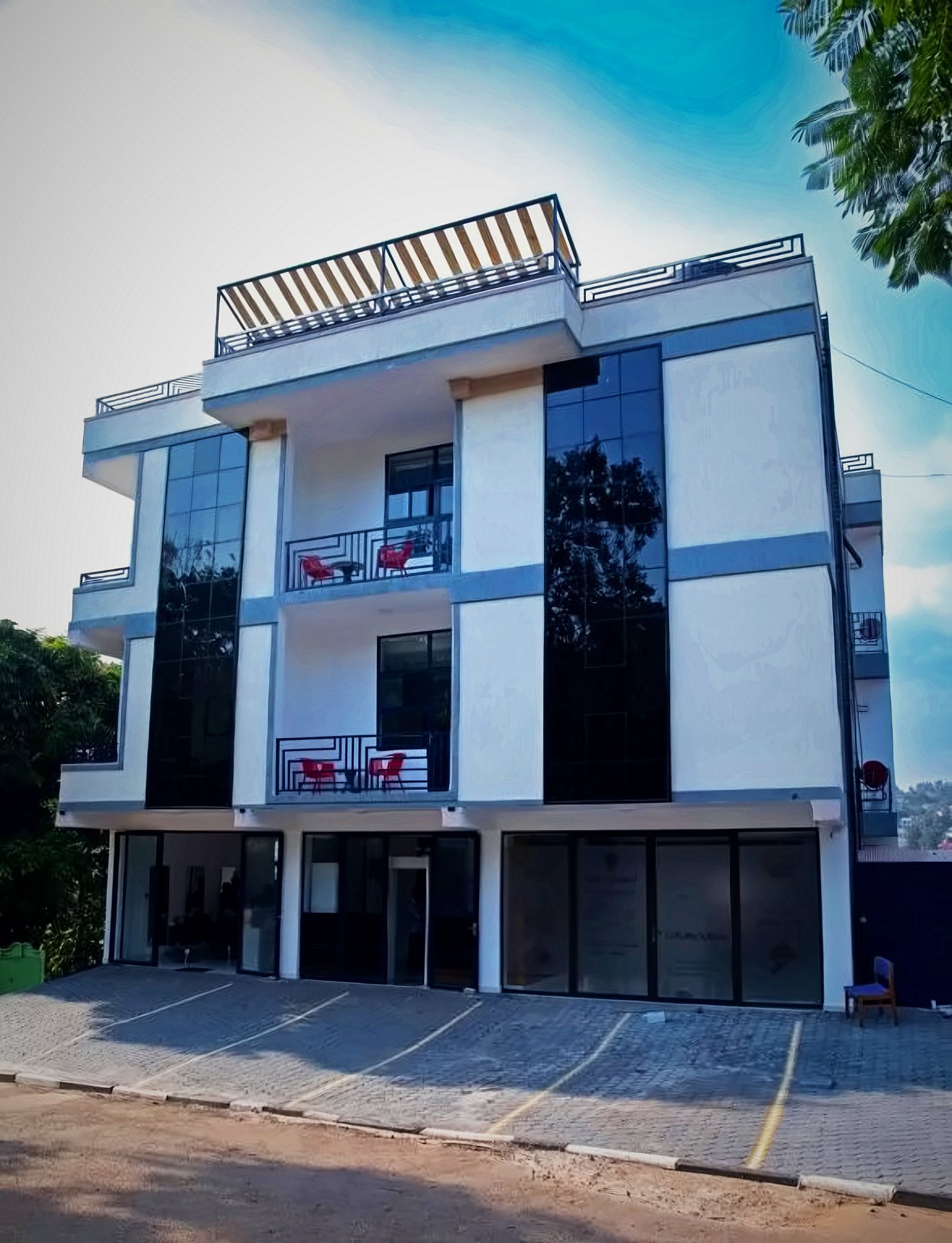 Exterior of the Holy Apartments building in Kigali: a modern block with balconies, a rooftop terrace and on-site parking
