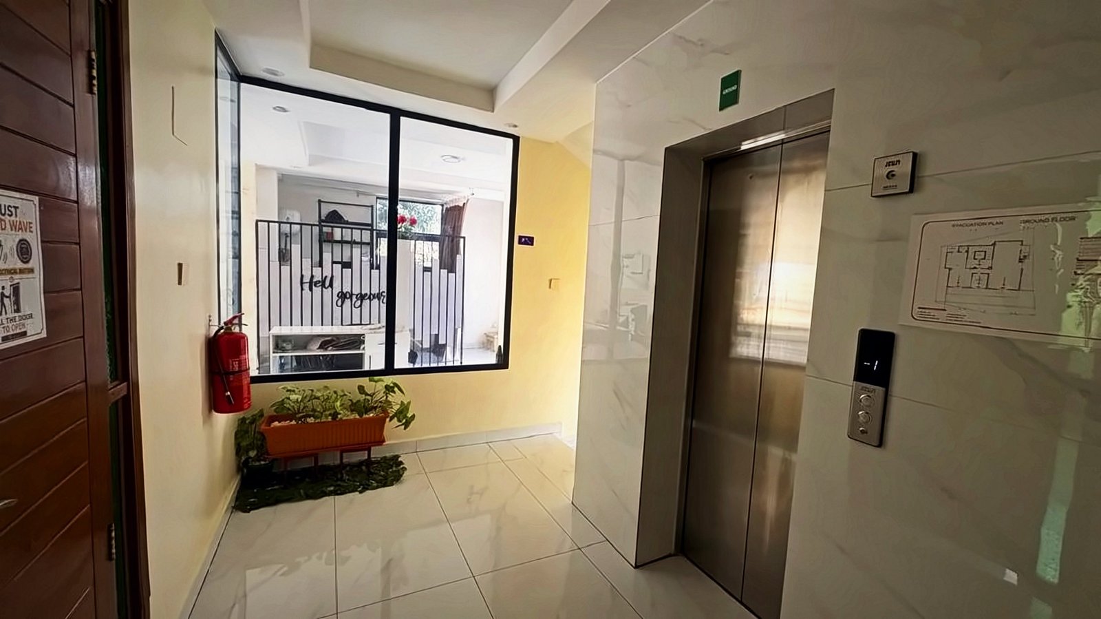 Bright landing with a lift and a window onto the courtyard at Holy Apartments, Kigali
