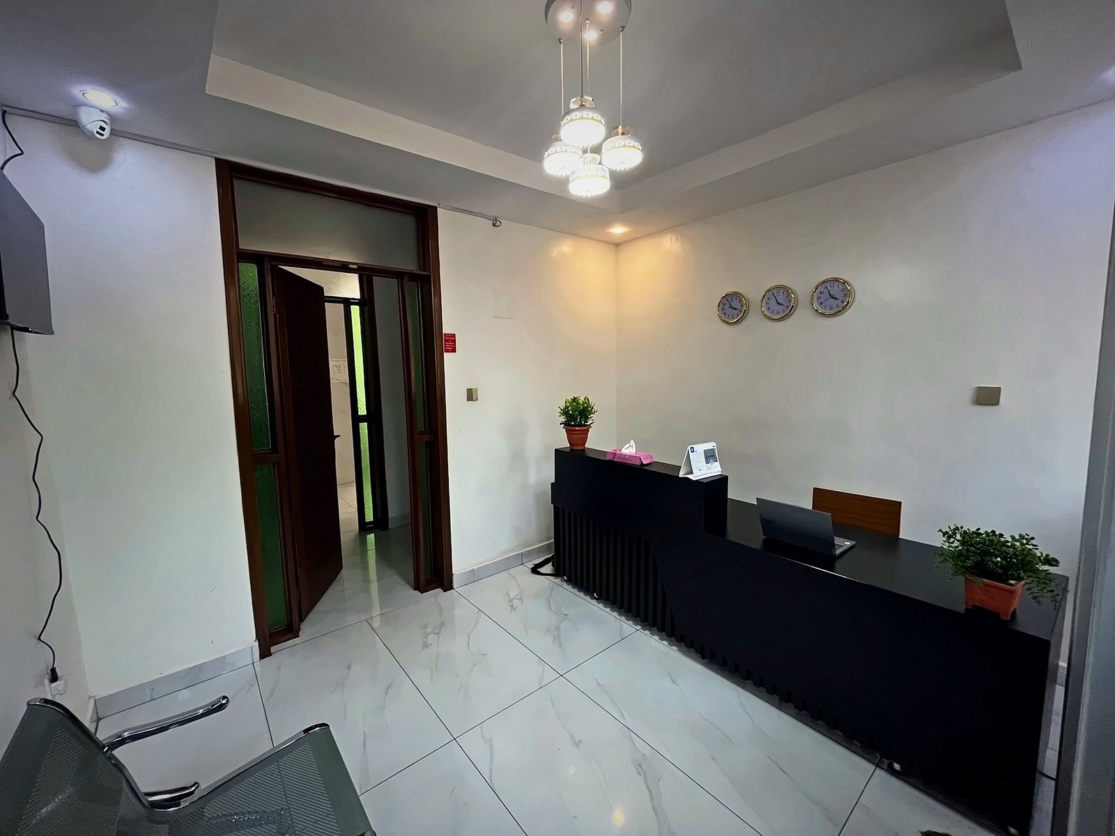 Reception area with a black front desk and a marble floor at Holy Apartments, Kigali